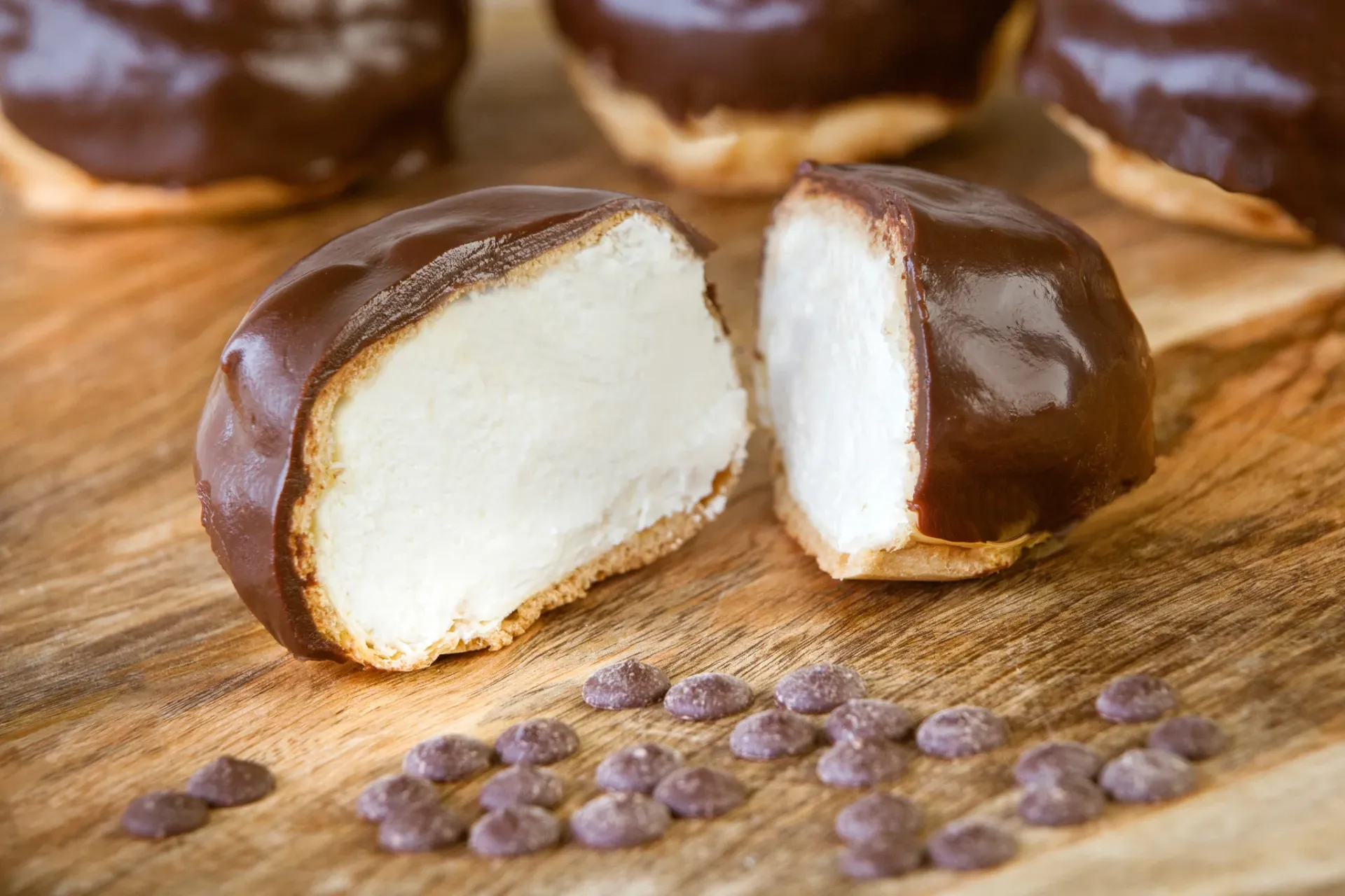 Bossche bollen op een houten plank — grote soezen met dikke pure chocoladelaag